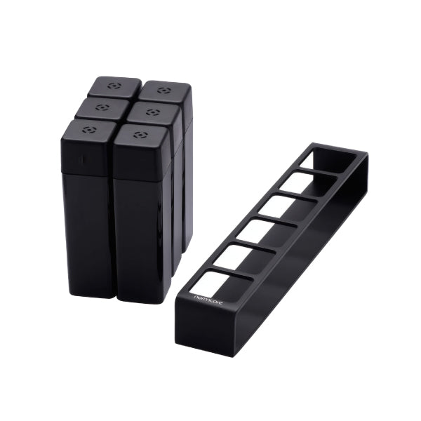 Six black Normcore Coffee Bean Cellars V2 tubes stacked beside the empty black six-slot stand