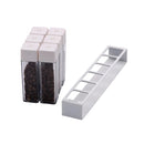 Six white Normcore Coffee Bean Cellars V2 tubes filled with coffee beans beside the empty white six-slot stand
