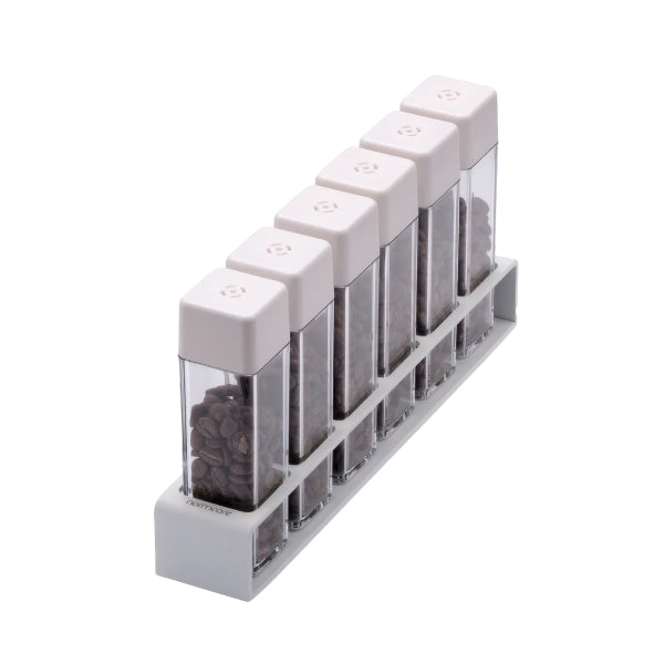 Normcore Coffee Bean Cellars V2 Set of 6 in white, six clear single-dose tubes with white lids filled with coffee beans in the white stand, angled view